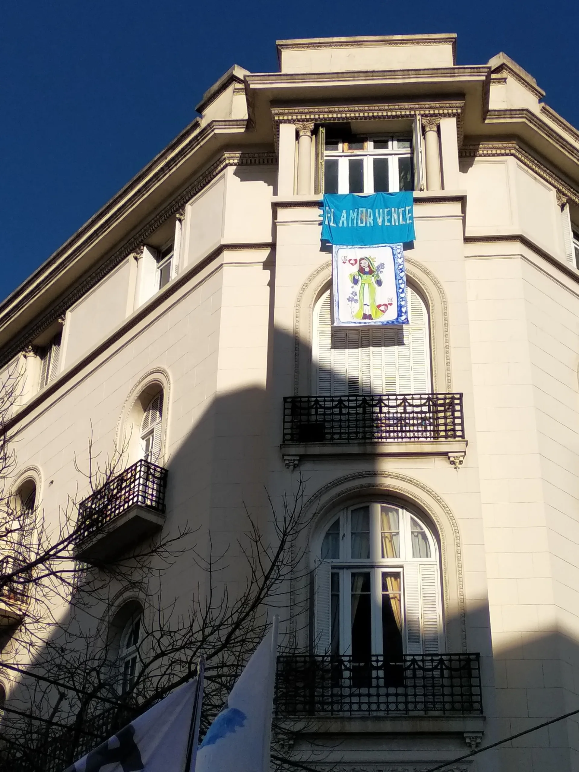 Una leyenda adorna el balcón por el cuál una multitud aguarda la aparición de Cristina Fernández de Kirchner.