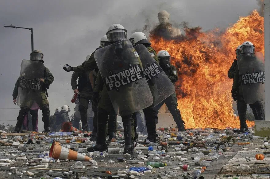 Grecia como laboratorio de ajuste económico | Ornitorrinco La policía antidisturbios frente a las llamas de un explosivo molotov frente al parlamento durante los enfrentamientos en el centro de Atenas, Grecia, para conmemorar dos años desde un mortal desastre ferroviario que también provocó cientos de otras manifestaciones y una huelga general, el viernes 28 de febrero de 2025. Foto: AP/Petros Giannakouris.