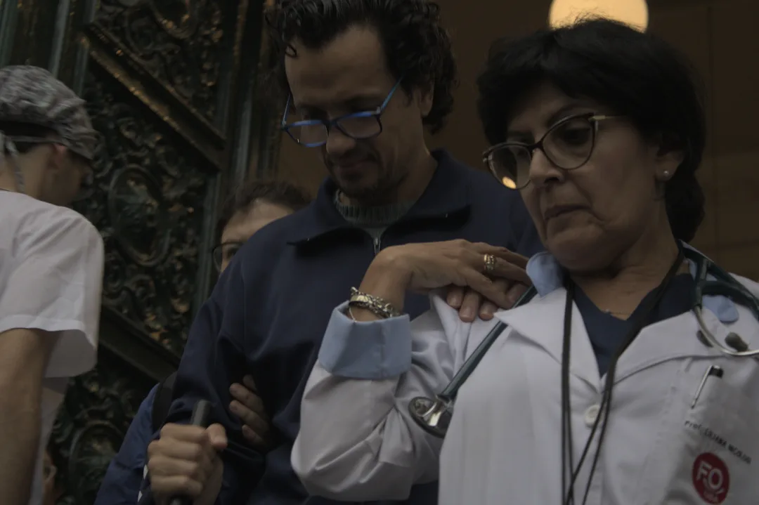 Una médica odontóloga acompaña a una persona no vidente durante el paro a la japones. Foto:: Shannon Prickett