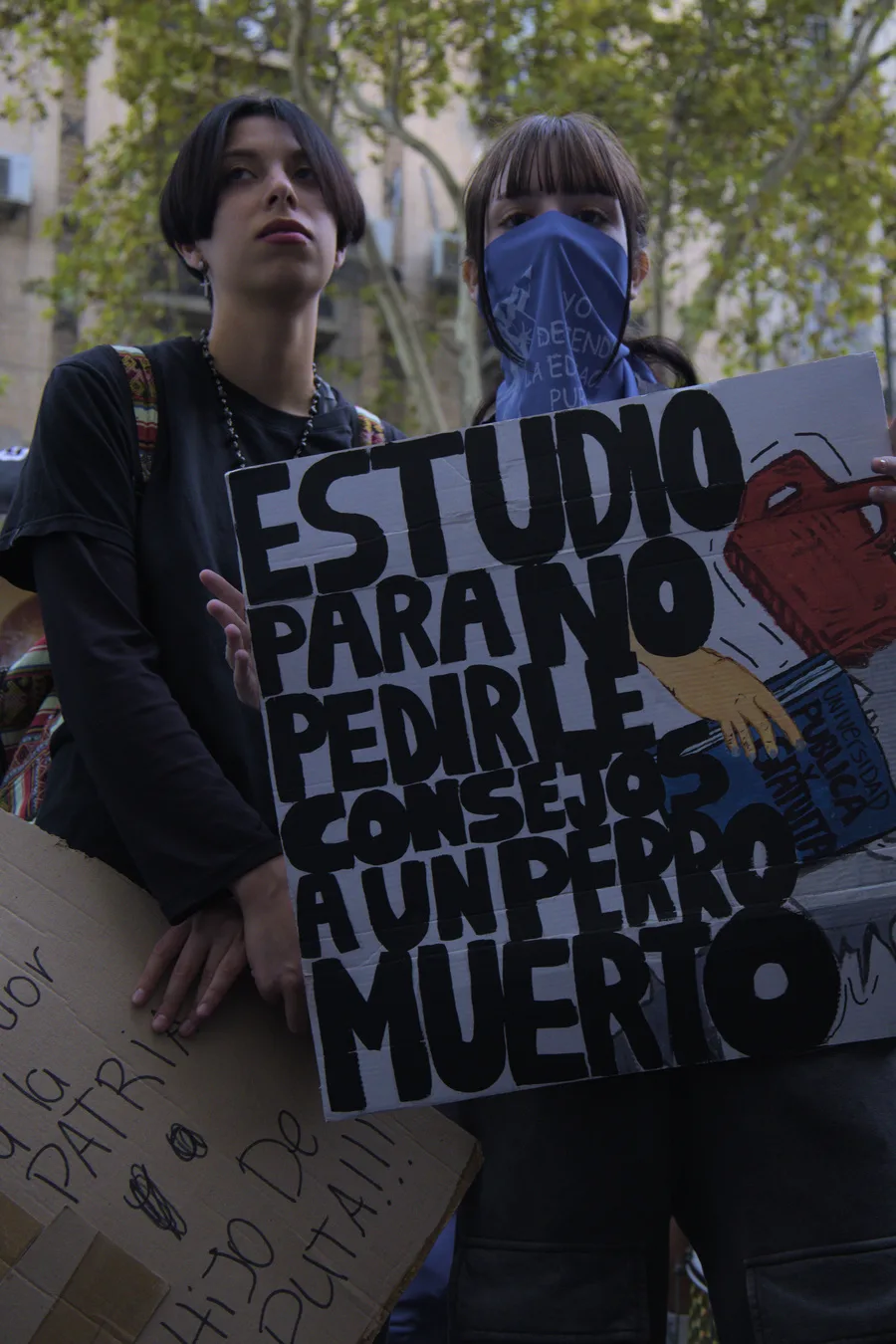 Estudiantes marchan para defender a la universidad con un cártel con un mensaje claro que apunta al Gobierno. Foto/Shannon Lynn Prickett